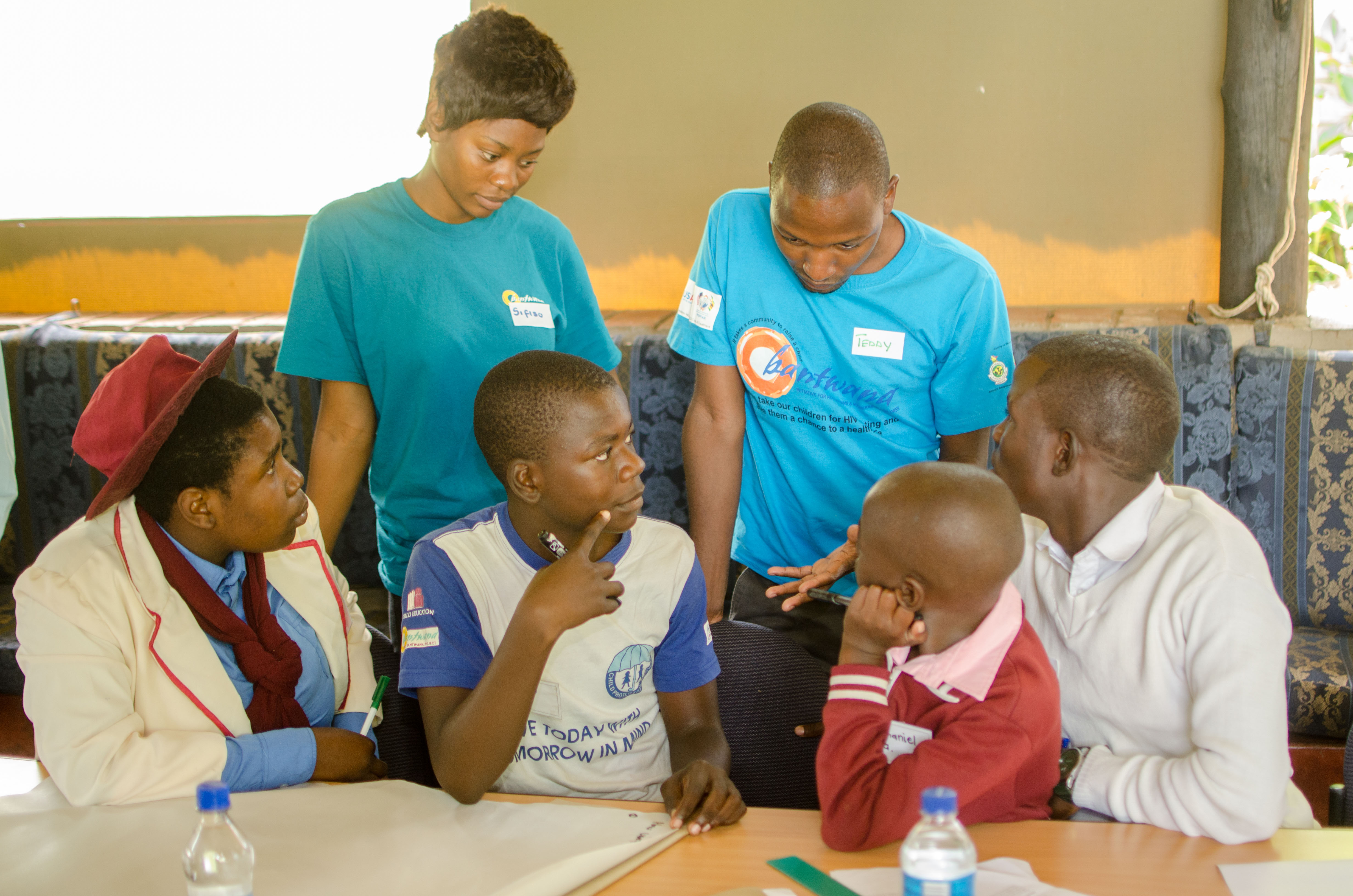 Bantwana staff talk with Zimbabwean Peer Leaders during a training