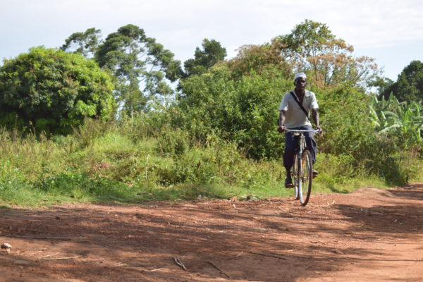 Swaib - Community Case worker rides his bike provided to him by Better Outcomes in Uganda