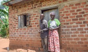 Waiswa and Samalie in front of their home in Uganda.