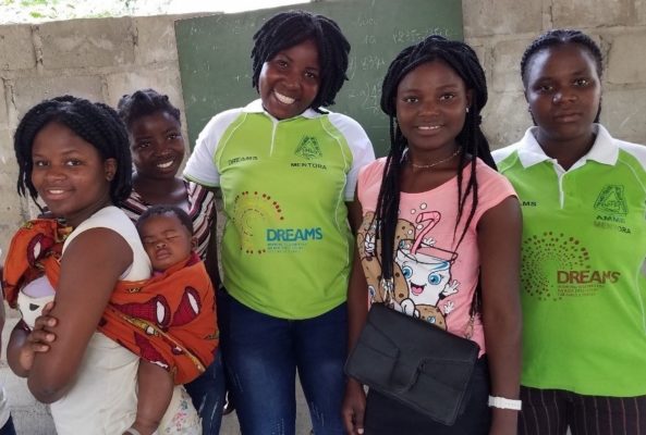 Olinda and Katya stand and pose for a photo with some of the girls they mentor through DREAMS IC in Mozambique.